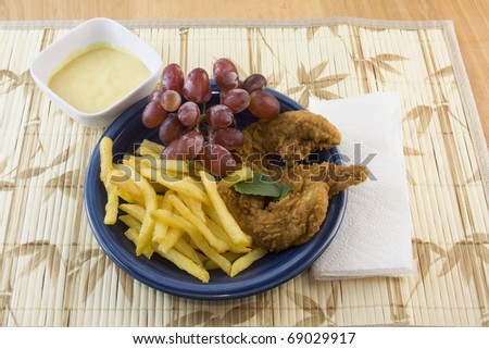fried chicken strips with french fries, red grapes, and honey mustard dipping sauce