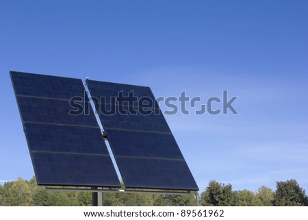a pair of large solar panels tracking the sun on a bright blue sky