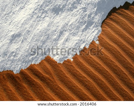 Desert sand meets the edge of a snow like stone monolith in the spectacular White Desert of Egypt.