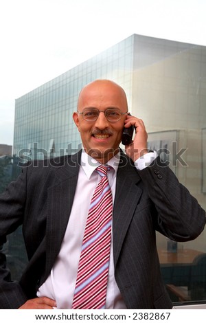 smiling businessman with phone on a background of a window