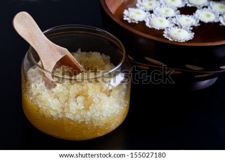 Body scrub and bowl with flowers