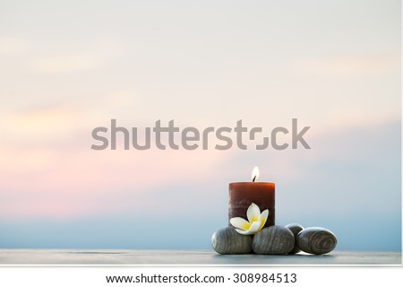 Plumeria flower, candle and stones for spa background