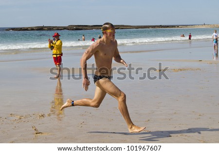 MOLLYMOOK, NSW, AUSTRALIA - APRIL 15 -  Brad Horrey winner of the Mollymook Beach Ocean Swim running towards the finish line on the 15th of April 2012.