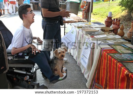 MARSEILLE, FRANCE - AUGUST 26: Photo of a young man in a wheelchair with his pet. Marseille Festival Association on August 26, 2012 in Park Borelli, Marseille, France