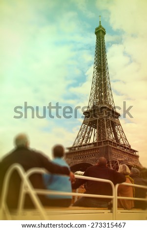 Abstract background .Tourists looking at the Eiffel Tower from the excursion boat. Blur effect defocusing filter applied, with vintage instagram look.