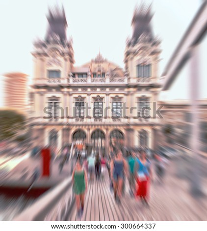 Abstract background. Pedestrians in front of the Port of Barcelona in the city center.  Radial zoom blur effect defocusing filter applied, with vintage instagram look.