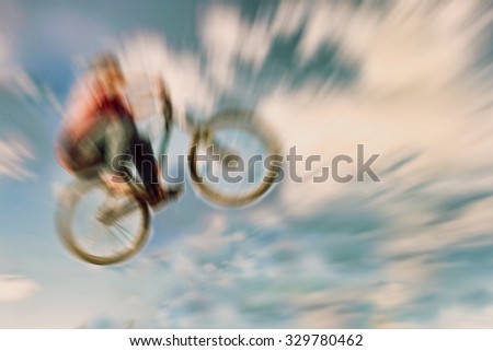 Abstract background. Boy on a BMX mountain bike jumping. Motion blur photo