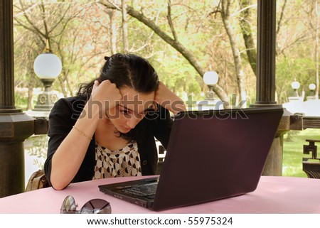 Young woman working on her laptop in nature