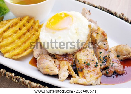 Roast chicken with red sauce and a fried egg.