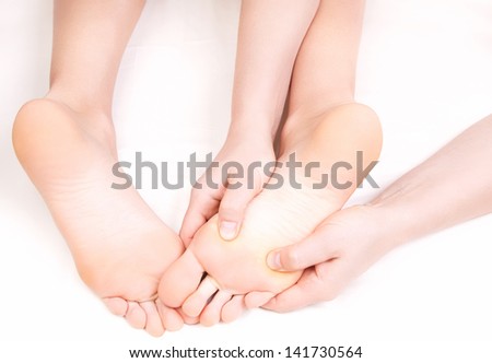 Therapist doing a foot massage,  pressing reflexology zones