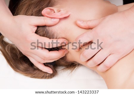 A woman getting a stress relieving pressure point massage on her neck by a therapist