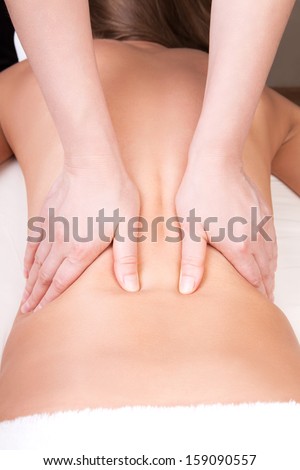 Deep tissue massage on the woman\'s middle back on latissimus dorsi muscle