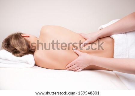 Deep tissue massage on the woman\'s middle back on erector spinae muscles