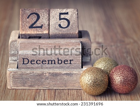 Old vintage wooden calendar set on the 25 of December  with christmas decoration