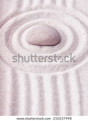 Zen garden with raked sand and round stone pattern of ripples and lines