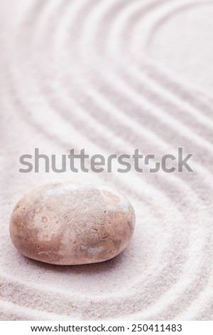 Zen garden with a marble rock and wave pattern in the sand