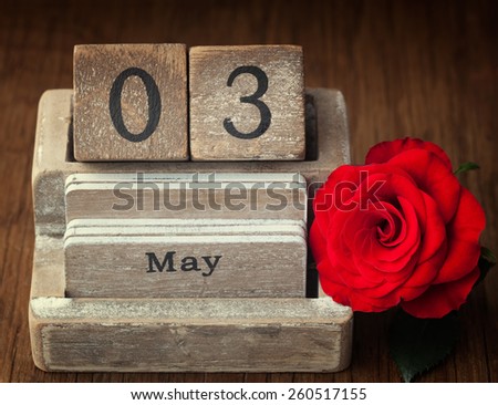 Old vintage calender showing the date 3rd of May which is the date of Mothers day in Spain, Hungary, Lithuania, Portugal, Romania, Mozambique with a red rose