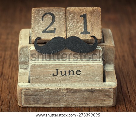 Old vintage calendar showing the date 21st of June which is the date of fathers day with wooden black mustache