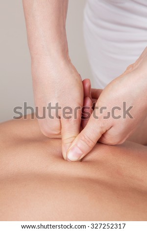 Deep connective tissue massage on a woman\'s shoulder blade