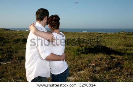 Young couple in love overlooking the ocean thinking about their future