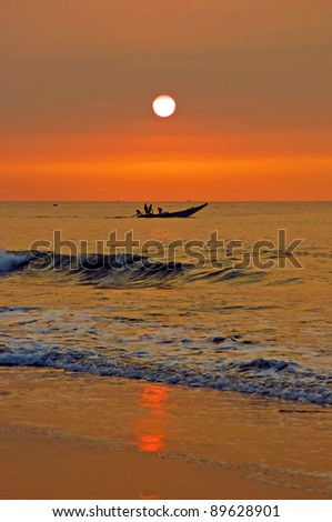 A group of men in the fishing boat at the sunrise