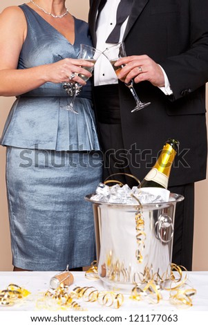 A couple in evening wear touching glasses for a Champagne toast, good image for New Years Eve, Wedding or Celebration themes.