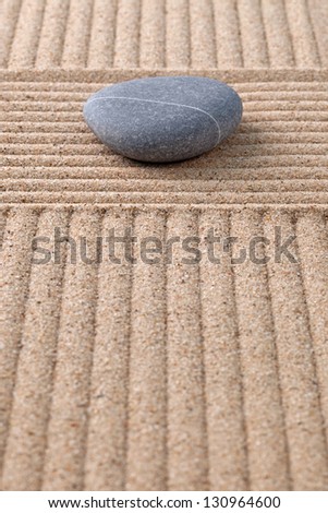 A pebble on a raked sand zen garden looking along the furrows.