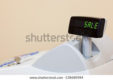 A cash register with the word SALE on the electronic display, copy space to add your own text.