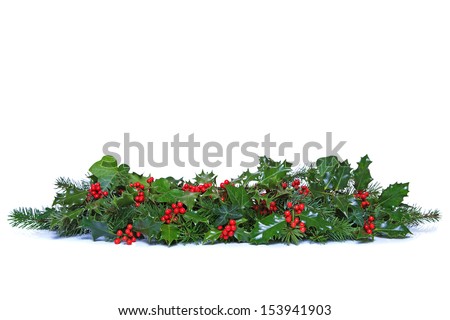 A traditional Christmas garland made from fresh holly with red berries green ivy leaves and sprigs of conifer spruce Isolated on a white background A traditional Christmas garland made from fresh holly with red berries green ivy leaves and sprigs of conifer spruce Isolated on a white background