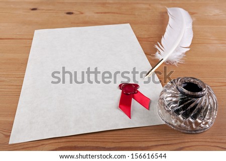 A blank piece of parchment paper with red wax seal, plus feather quill and glass ink well on a desk, add your own text for a certificate, diploma or important document.