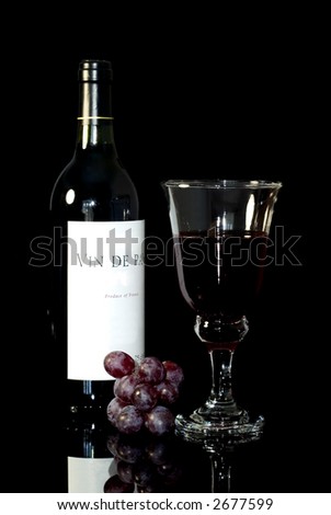 Wine still life, Bottle of Vin de Pays (Country Wine),Glass and red grapes. Black background.