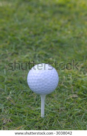 Golf ball on white wooden tee, space above for copy.