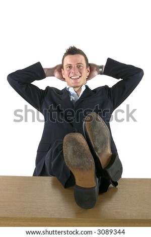 Businessman leaning back on a chair with his feet on the desk
