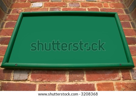 Old green sign on a red brick wall, unusual perspective, blank for your text.