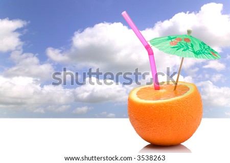 Concept image of a Summer orange cocktail against blue sky.