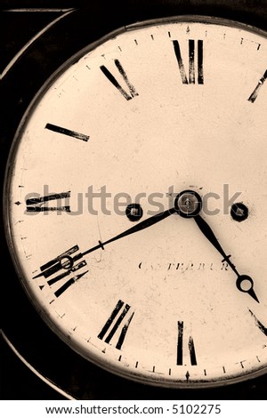 Close cropped image of an antique clock, dark and grainy sepia toned image.