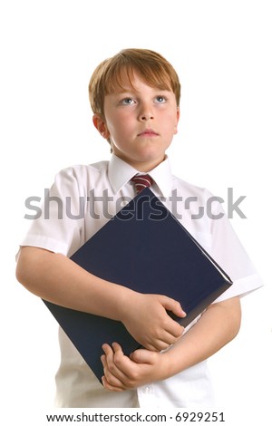 A young schoolboy holding a reference book looking up