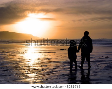 stock photo : Two children holding hands whilst watching a beach sunset.