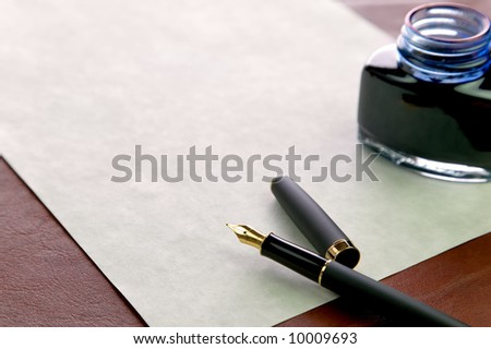 Gold nibbed fountain pen, watermarked expensive paper and an inkwell on a leather desk top, shallow DOF, focus on the nib.