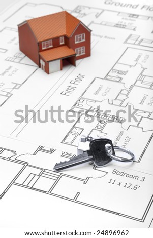 A model home and house key on architectural floor plans.