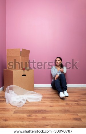 Young woman taking a break from packing during a home move. Plenty of copy space.
