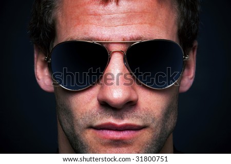 Close up portrait of a man wearing gold rimmed aviator sunglasses, clipping path for the lenses to add your own reflection.