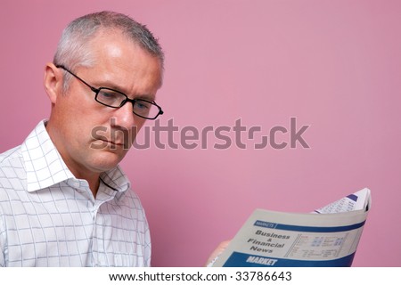 Businessman reading the latest share prices in a financial newspaper