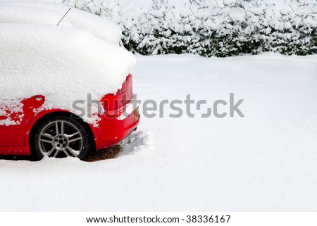 Back of a red car covered after a recent snowfall