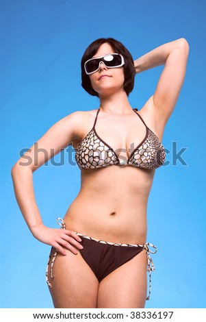 stock photo short haired brunette woman posing in a brown bikini against a bright blue sky 38336197
