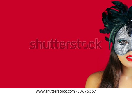 Beautiful brunette woman wearing a masquerade mask against a red background.