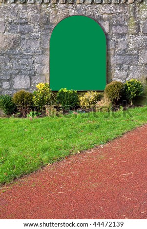 Blank green sign on an old stone wall, add your own message.
