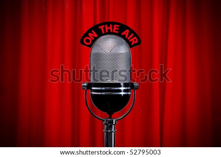 Retro microphone on stage against a red curtain with spotlight effect