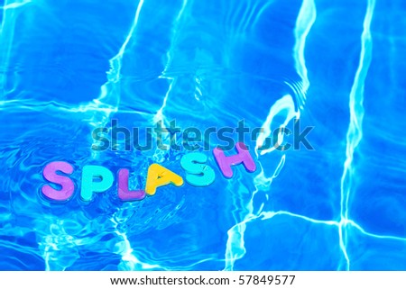 The word SPLASH made from foam letters floating on the water surface of a swimming pool