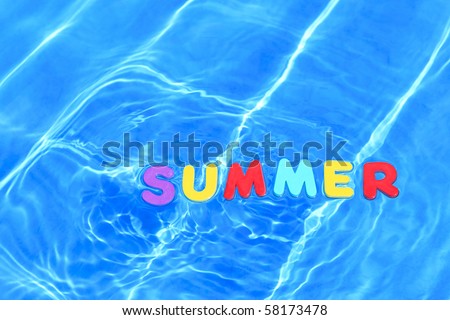 Photo of the word SUMMER made from foam letters floating in water on the surface of a swimming pool.